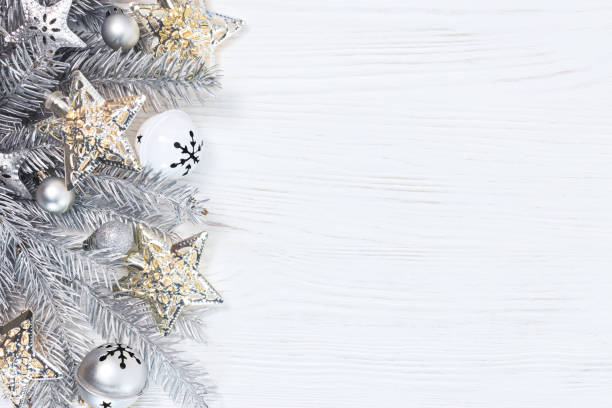 istock silver christmas fir tree branches with lights garlands and holiday decorations on white wooden background 882792294
