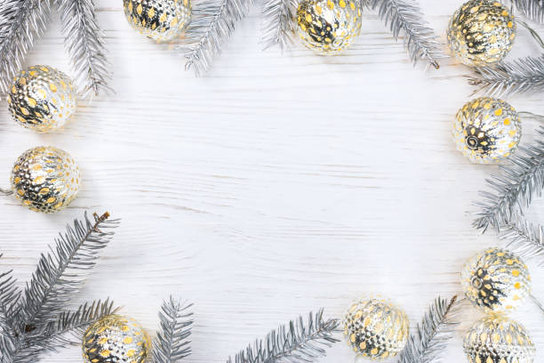 istock silver christmas tree branches decorated with glowing light garlands on white wooden table. holiday background. 882795762
