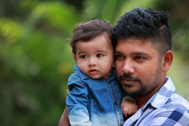 istock Affectionate young man holds his baby in arms 882802530