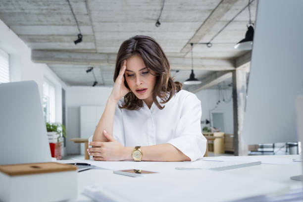 Female entrepreneur with headache sitting at desk Female entrepreneur with headache sitting at desk. Businesswoman under terrible physical tension at work. disappointment stock pictures, royalty-free photos & images