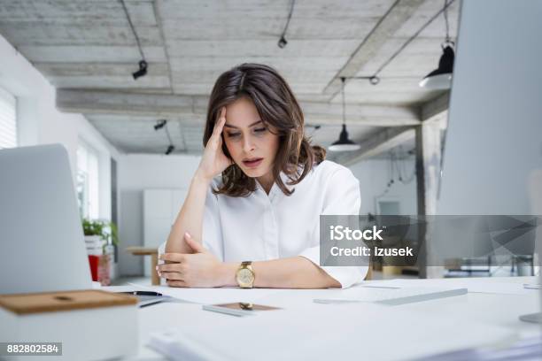 Female Entrepreneur With Headache Sitting At Desk Stock Photo - Download Image Now - Working, Women, Emotional Stress