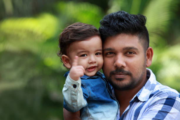 istock Affectionate young man holds his baby in arms 882802632