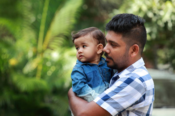istock Affectionate young man holds his baby in arms 882802714