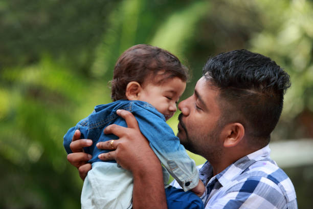 istock Affectionate young man holds his baby in arms 882802764