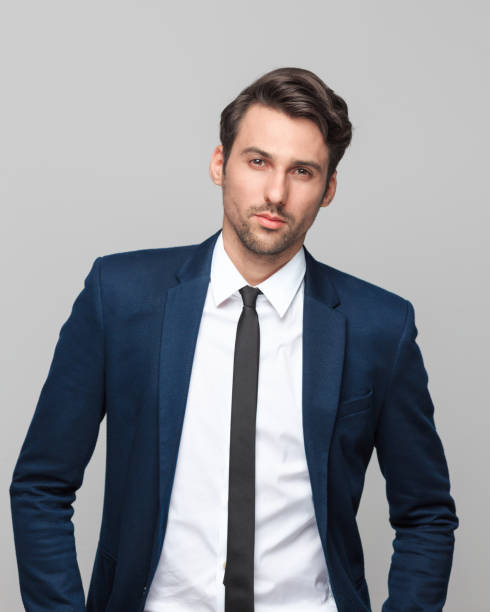 istock Confident businessman standing against grey background 882803206