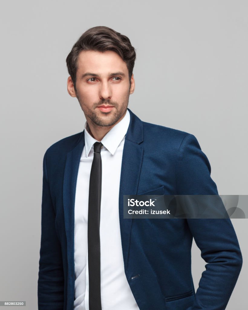 Portrait of handsome young businessman Portrait of handsome young businessman standing on grey background and looking away 25-29 Years Stock Photo