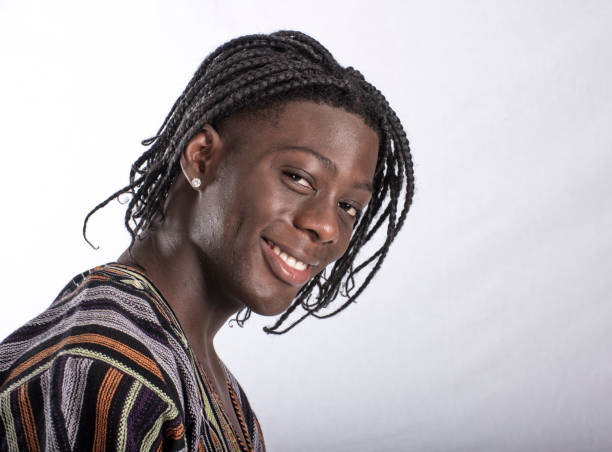 Smiling young man from Sierra leone looks over shoulder at camera. Space around portrait.