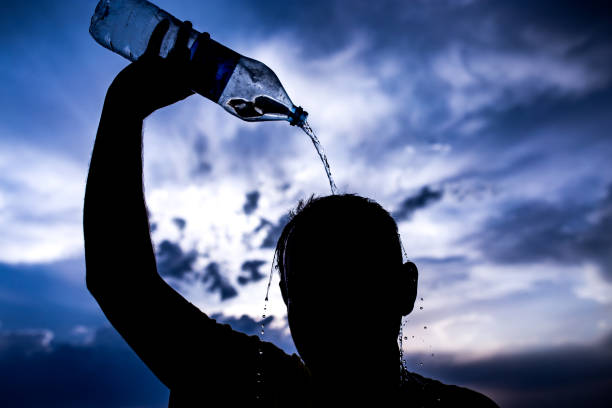 istock man pours water on his head in the sunset 882812466