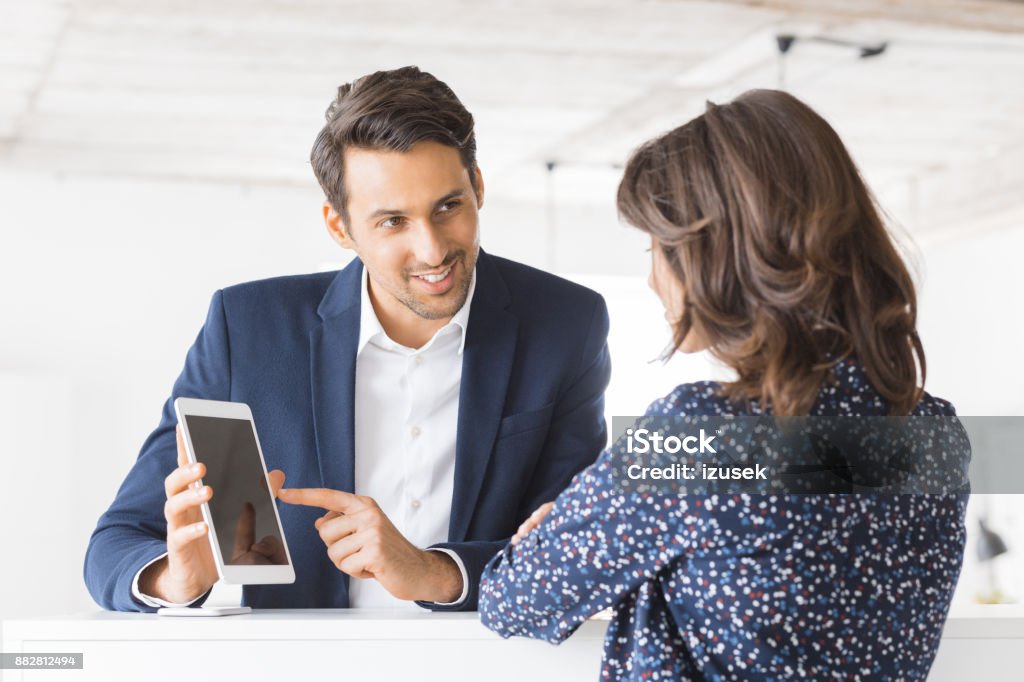 Business colleagues working together in office Businessman showing a proposal on digital tablet to female colleague. Two business people working together at office using digital tablet. 20-29 Years Stock Photo