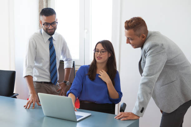 istock Positive colleagues analyzing report on laptop 882812822
