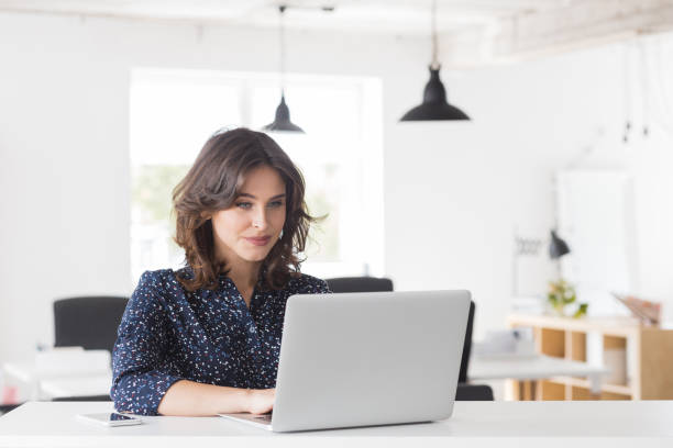 istock Beautiful young businesswoman using laptop 882812896