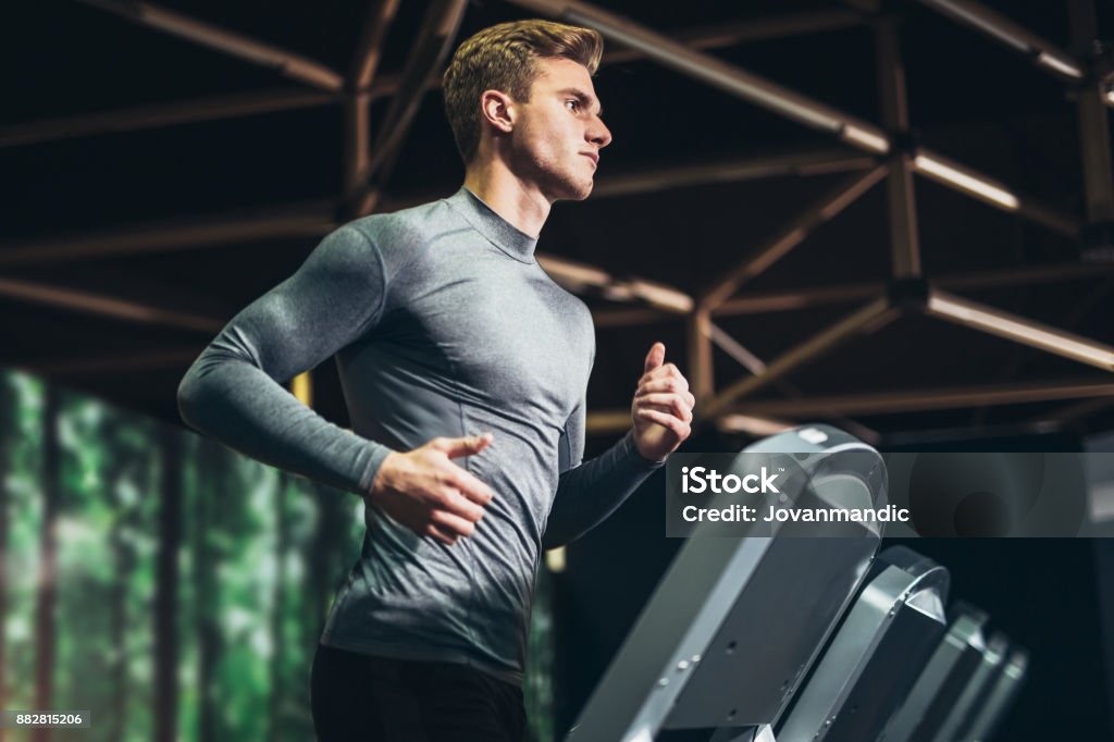 Man running at the gym Man running in a gym on a treadmill concept for exercising, fitness and healthy lifestyle Men Stock Photo