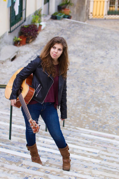 istock Girl Holding Guitar and Standing on Stairway 882827698