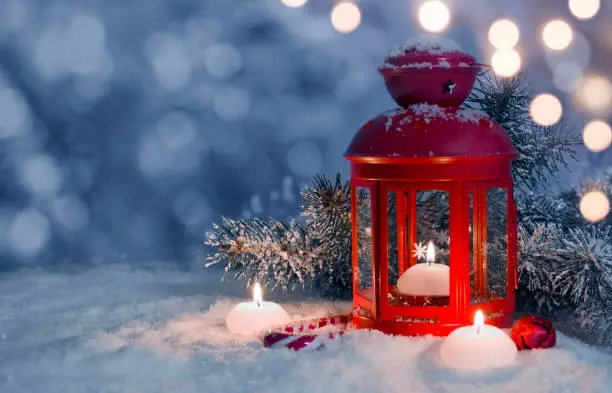 Photo of Christmas decorated lantern and candles on snow with copy space