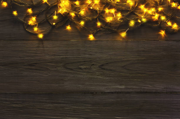 istock Christmas lights border on grey wooden background 882836286