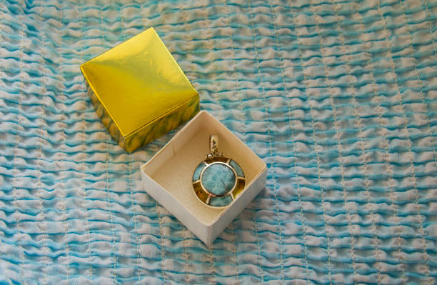 small larimar and blue amber pendent in a paper gift box