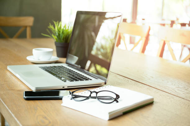 istock Selected focus laptop with cell phone notebook and glasses and coffee cup 882848332