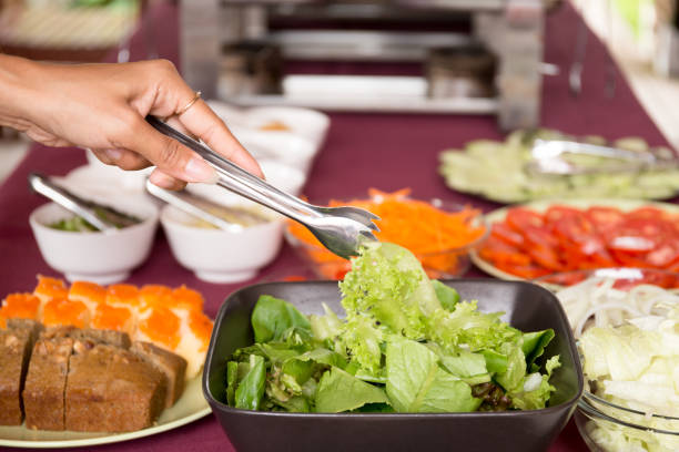 istock Selected focus woman taking fresh vegetable salad from salad bowl 882850924