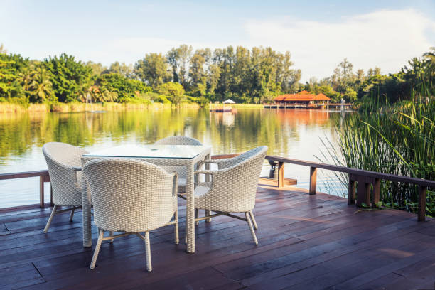 istock Outdoor white garden dining table by water side 882856112