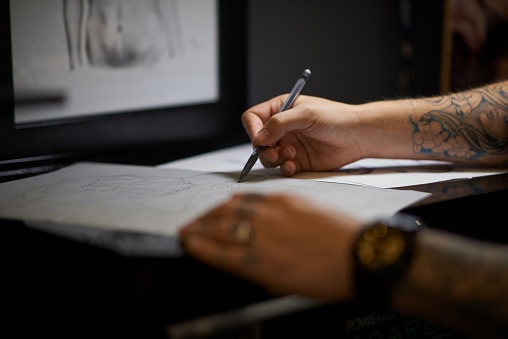 Shot of a tattoo artist drawing new designs