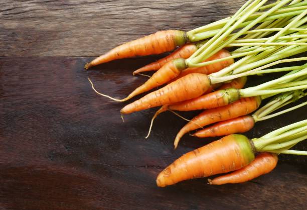 carotte de bébé sur la table en bois. - carrot baby carrot peeled isolated photos et images de collection