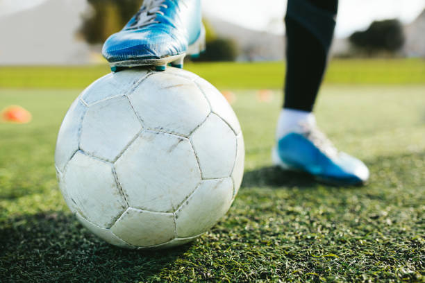 istock Soccer player standing on pitch with ball 882866802