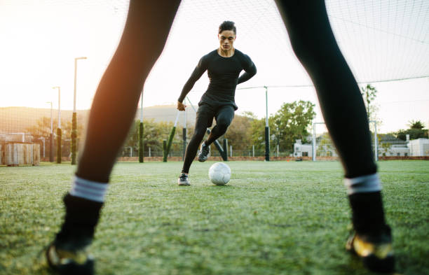 Soccer players during practice Soccer players during practice on football ground. Young footballer playing on the grass field. soccer team captain stock pictures, royalty-free photos & images
