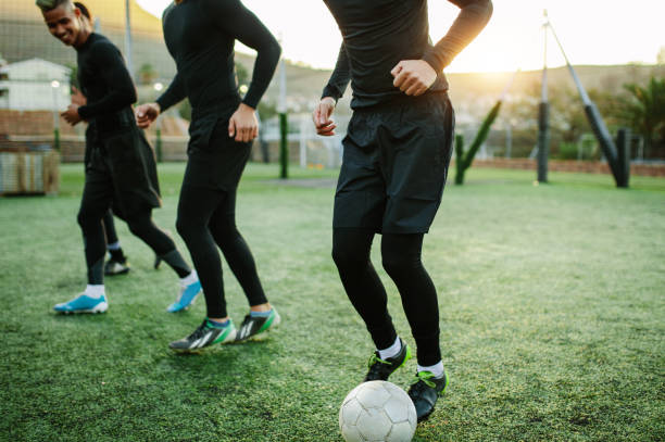 istock Teenagers practicing football on field 882871070