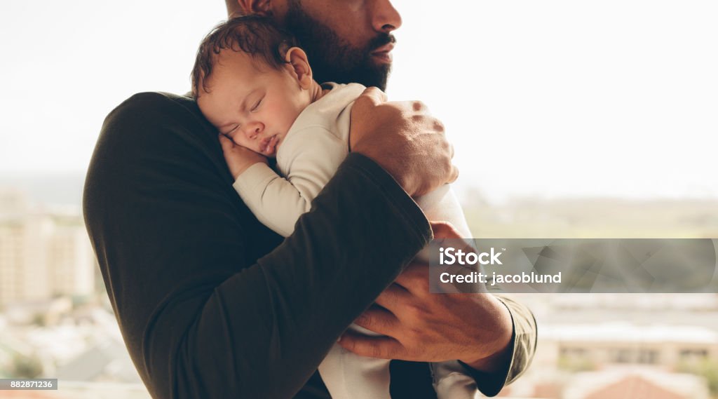Newborn baby boy in his father's arms Man carrying his sleeping son. Newborn baby boy in his father's arms. Father Stock Photo