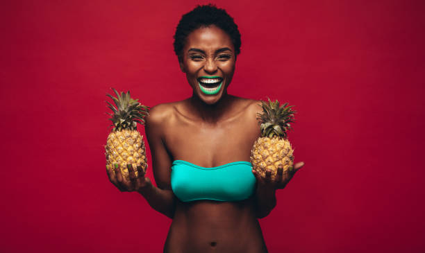istock Happy african woman holding fresh pineapples 882874208
