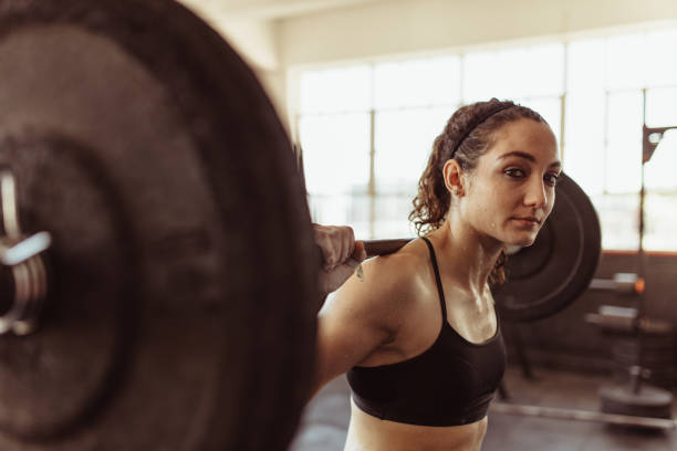 istock Female working out at gym with heavy weights 882881732