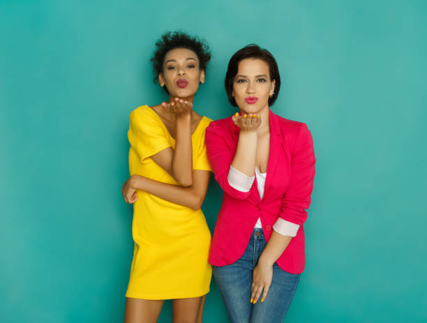 istock Two girlfriends blowing kisses at azur studio background 882885944