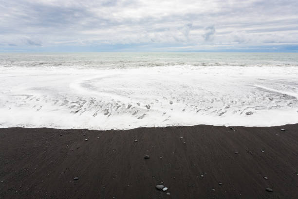 istock surf on Reynisfjara black Beach in Iceland 882898182
