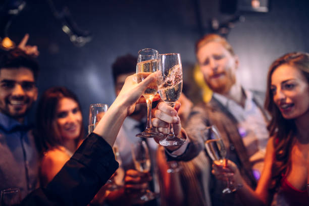 Let's kick this party into high gear ! Cropped shot of friends celebrating with champagne office parties stock pictures, royalty-free photos & images