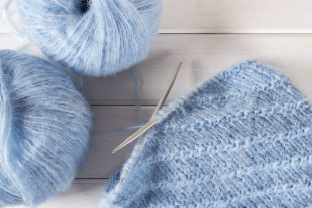istock Blue knitting wool yarn and knitting needles. Incomplete knitting project 882906452