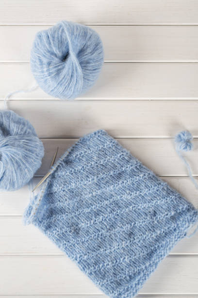 istock Blue knitting wool yarn and knitting needles. Incomplete knitting project 882906456