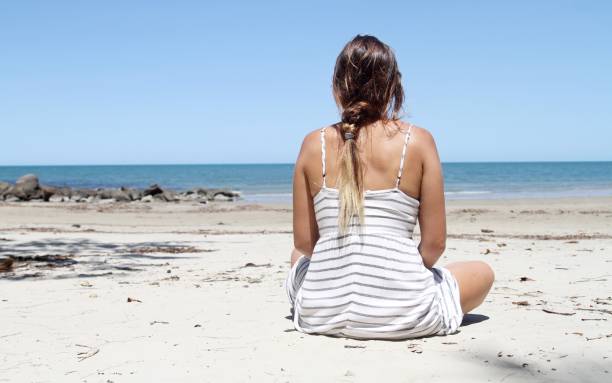 istock back view of young woman on beautiful beach 882918466
