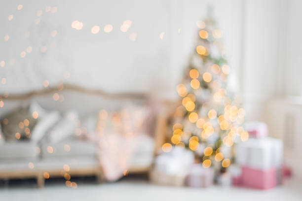 istock Blurred background. Luxury living room interior with sofa decorated chic Christmas tree, gifts, plaid and pillows 882922088