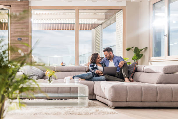 istock Happy couple in love communicating while using laptop at home. 882934376