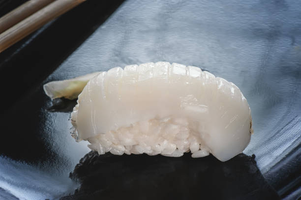 japanisches sushi reis und wolfsbarsch mit stäbchen auf einer schwarzen platte gemacht. - flounder fillet seafood meal stock-fotos und bilder