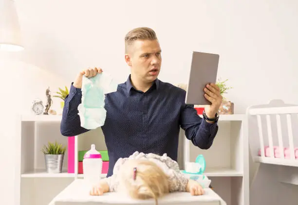 Photo of Man doesn't know how to change diapers.