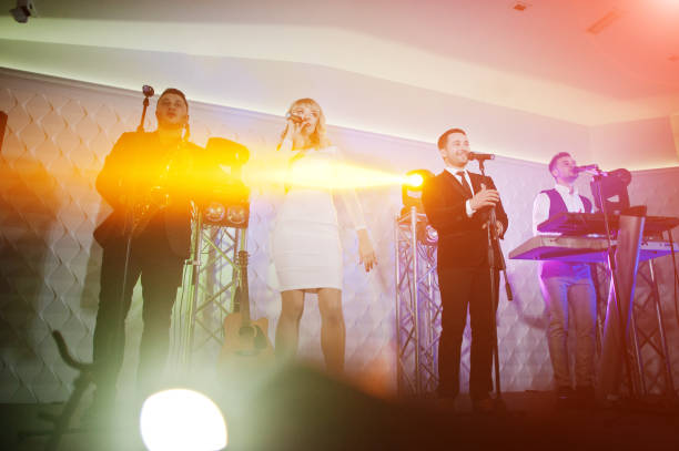 Musicial music live band performing on a stage with different lights.