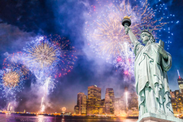 la statue de la liberté avec l’arrière-plan flou du paysage urbain avec des feux d’artifice magnifique nuit, manhattan, new york city - statue of liberty liberty statue firework display photos et images de collection