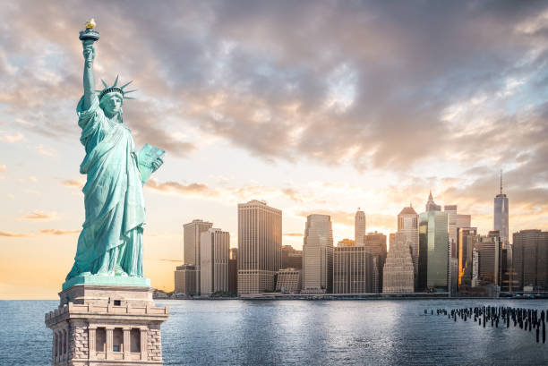 The Statue of Liberty with Lower Manhattan background in the evening at sunset, Landmarks of New York City stock photo