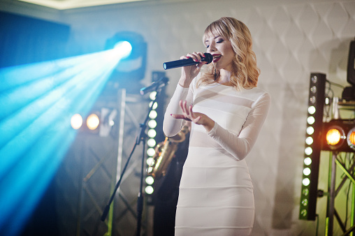Beautiful blonde vocal singer girl on stage.
