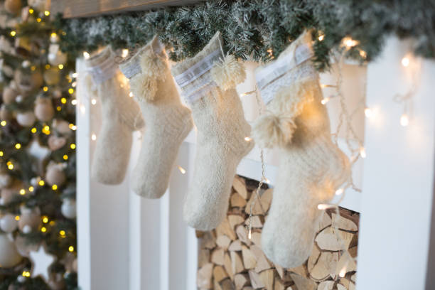 istock Three Christmas gift in knitted socks above the fireplace. 882959952
