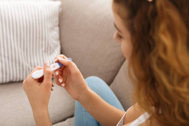 chica preocupada leyendo los resultados de su prueba de embarazo - prueba de embarazo fotografías e imágenes de stock