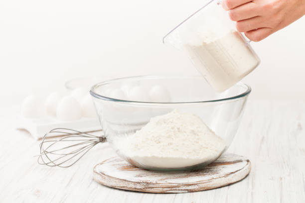 istock Flour in a Cup on a white table in the kitchen 882984814
