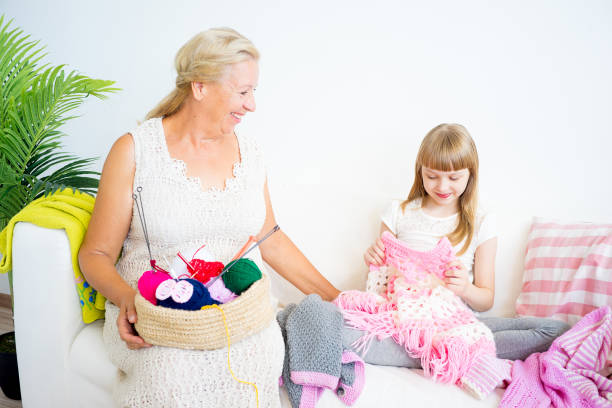 istock Grandmother knitting with granddaughter 882985104