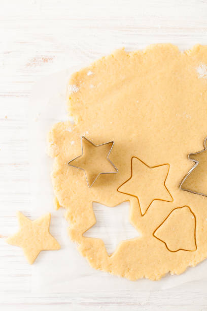 istock Cut the cookie shape from the dough at the white table. View with copy space 882987866